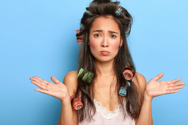 Pretty young woman posing with hair curlers