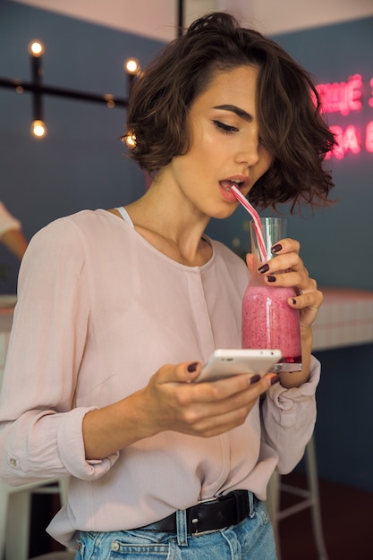 Pretty young woman typing message on mobile phone