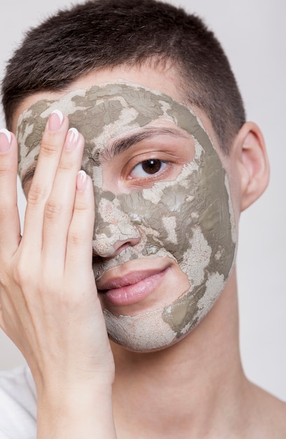 Giovane donna graziosa che usando il primo piano della maschera di protezione