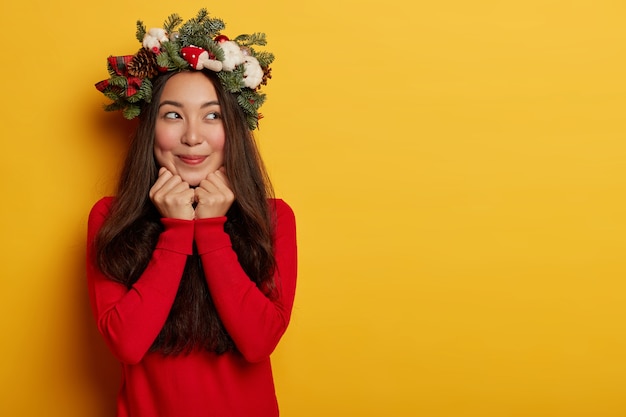 Foto gratuita bella e giovane donna che indossa la corona di natale sulla sua testa