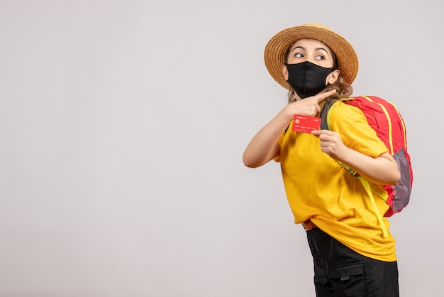 pretty young woman with black mask holding credit card on white