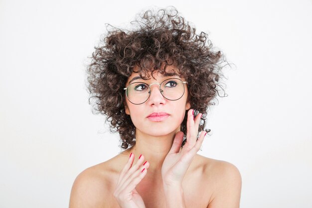 Pretty young woman with eyeglasses against white backdrop