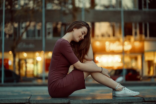 Bella giovane donna con le caratteristiche del viso da favola con luci della città