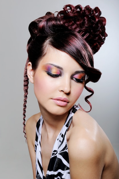 Foto gratuita bella giovane donna con acconciatura creativa di moda e ombretto multicolore luminoso