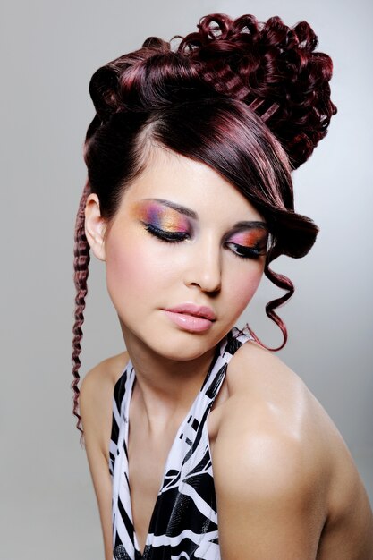 ファッション創造的な髪型と明るい色とりどりのアイシャドウを持つかなり若い女性