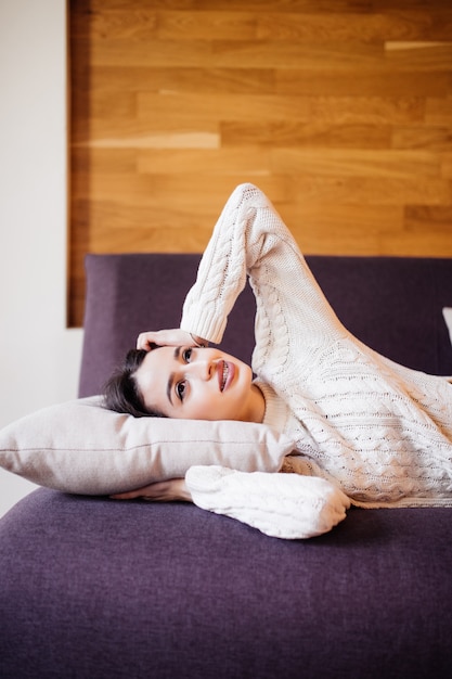 Foto gratuita bella giovane donna si svegliò dopo un pisolino quotidiano tra un lavoro da fare sul divano scuro nel suo appartamento