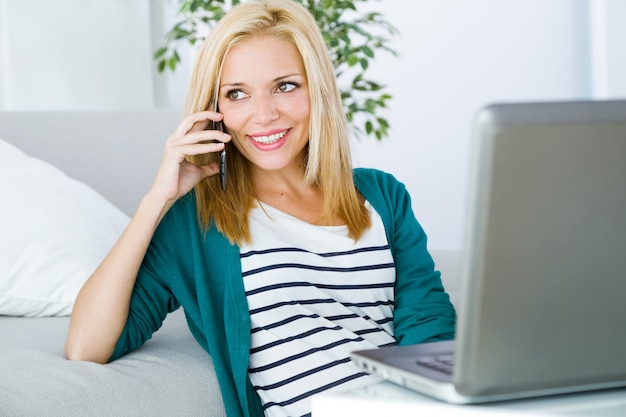 Pretty young woman working and using her mobile phone.