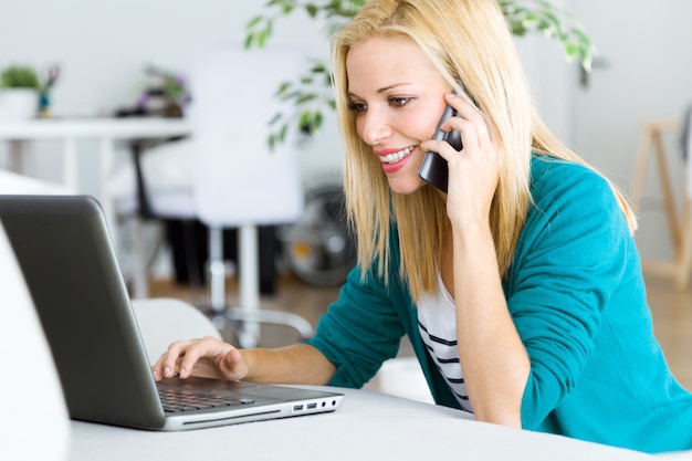 Foto gratuita pretty giovane donna che lavora con il computer portatile a casa.