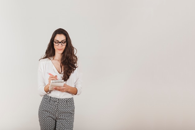 Pretty young woman writing in a notebook