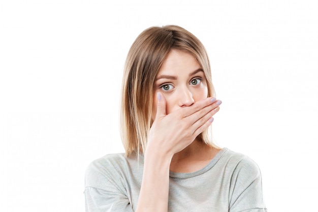 Pretty young young woman covering her mouth with hand