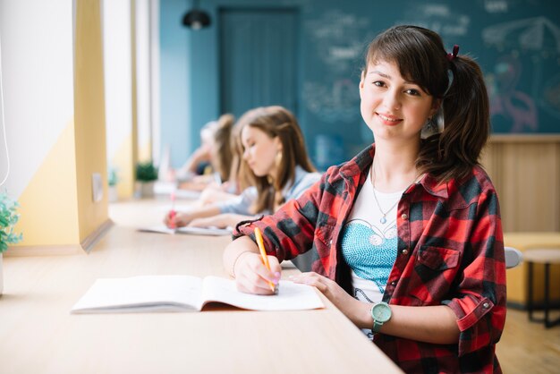 pretty youngster sitting at desk in class