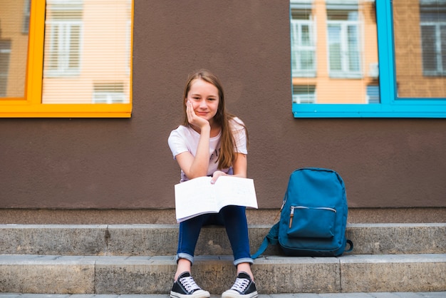 Pretty youngster with studies on pavement