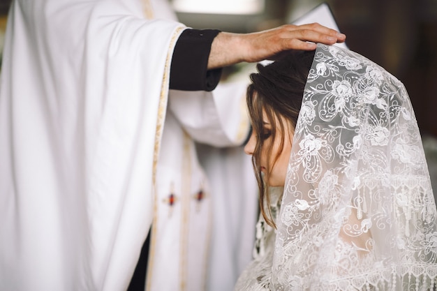 Il sacerdote benedice la sposa durante la cerimonia in chiesa