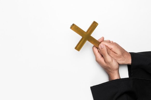 Foto gratuita sacerdote tenendo in mano una croce santa