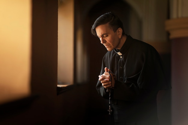 Priest praying in church