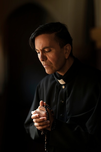 Free photo priest praying in church