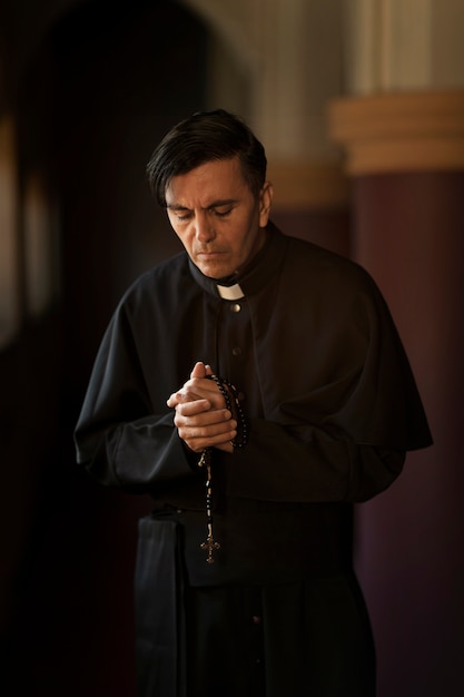Священник молится в церкви
