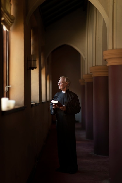 Free photo priest praying in church