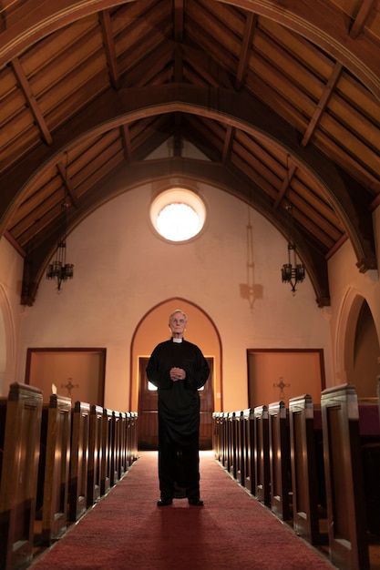 Priest praying in church