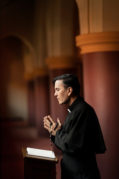 Priest praying in church