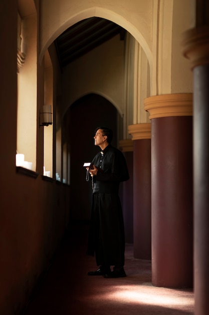 Foto gratuita sacerdote che prega in chiesa