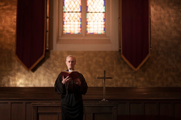 Free photo priest reading from bible