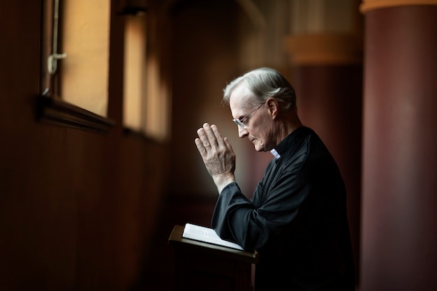 Foto gratuita sacerdote che legge dalla bibbia