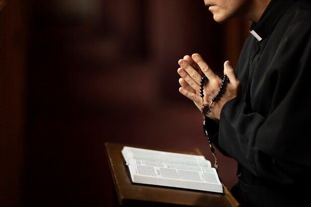 Foto gratuita sacerdote che legge dalla bibbia