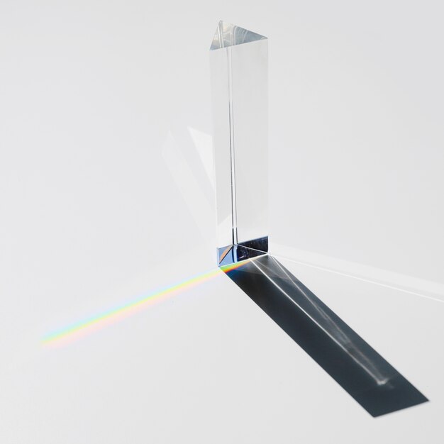 A prism dispersing sunlight splitting into a spectrum on a white background