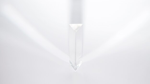 A prism dispersing sunlight on a white background