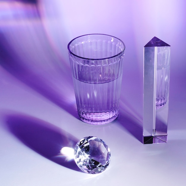 プリズム;輝くダイヤモンドと紫色の光沢のある背景に水のガラス