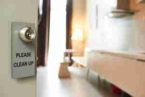 Free photo privacy sign hanging on handle of open door to hotel room