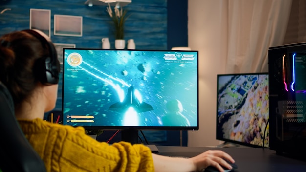 Профессиональный киберспортсмен, играющий в игру с RGB-клавиатурой и мышью. Чемпионат по виртуальному шутеру в киберпространстве, киберспортсмен выступает на компьютере в стильной комнате во время игрового турнира