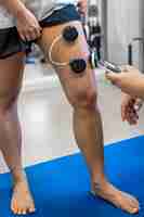 Free photo the procedure of myostimulation on the legs of a woman