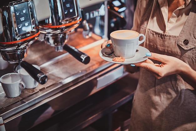 経験豊富なバリスタによるカフェでの真新しいコーヒーマシンを使用したコーヒー製造のプロセス。