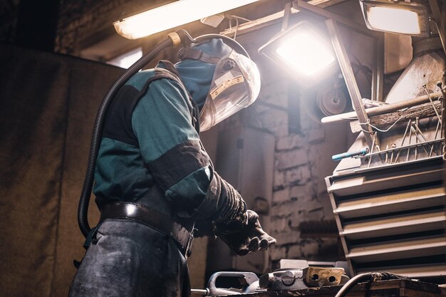 Process of creating new metal parts at busy workshop made by worker.