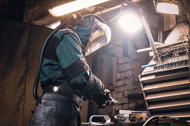 Process of creating new metal parts at busy workshop made by worker.