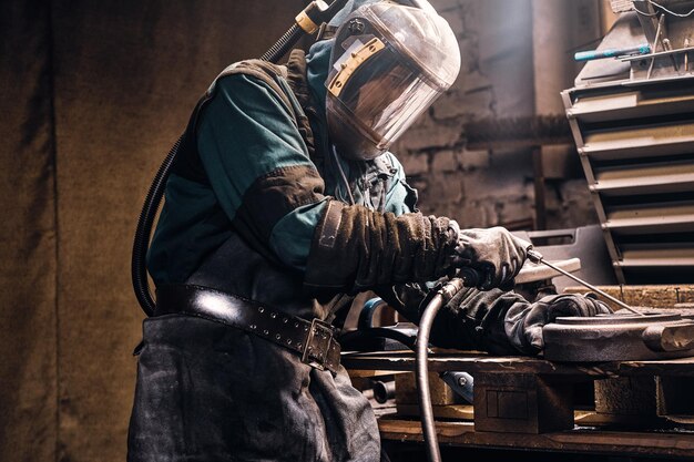 労働者によって作られた忙しいワークショップで新しい金属部品を作成するプロセス。