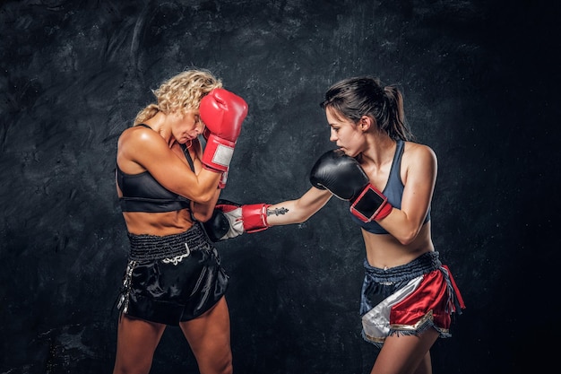 Process of fight between two female boxers, one of them got hit from another.