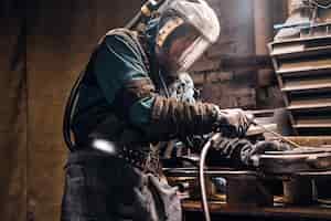 Бесплатное фото Процесс создания новых металлических деталей в оживленной мастерской, сделанный рабочим.