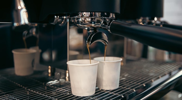 プロのコーヒーマシンのクローズアップでエスプレッソを準備するプロセス