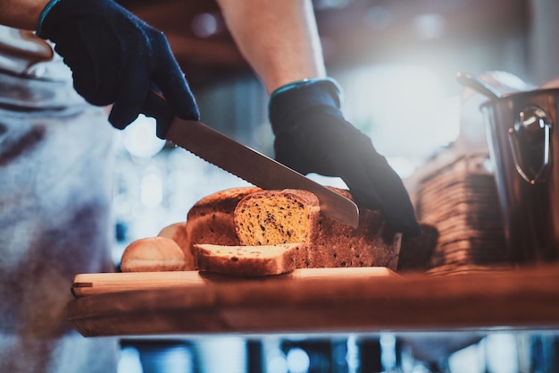 Process of seeded loaf slicing at the kitchen for breakfast at posh hotel by baker.