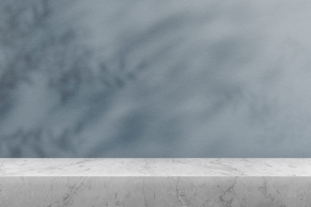 Product backdrop, empty marble table top with blue wall and plant shadow