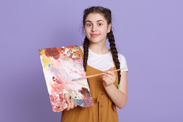 Free photo professional artist smiling with paint brush and palette