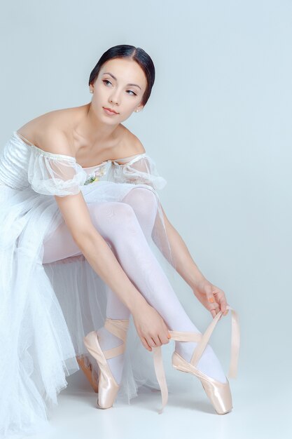 Professional ballerina putting on her ballet shoes