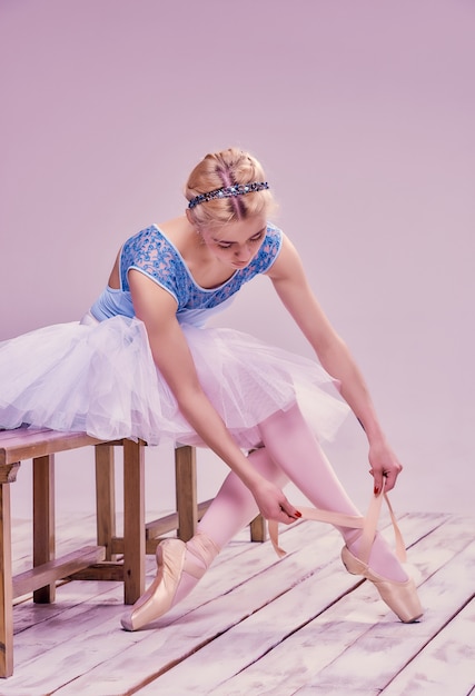 Professional ballerina putting on her ballet shoes.