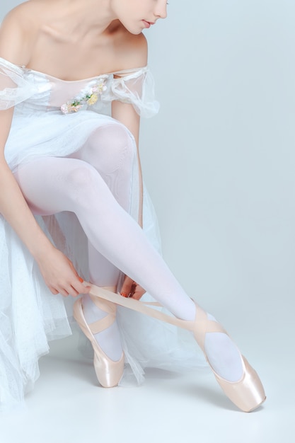 Бесплатное фото Профессиональная балерина надевает балетные туфли