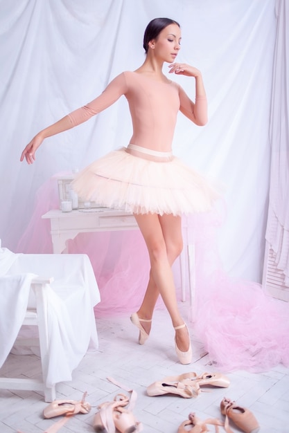 Professional ballet dancer posing on pink