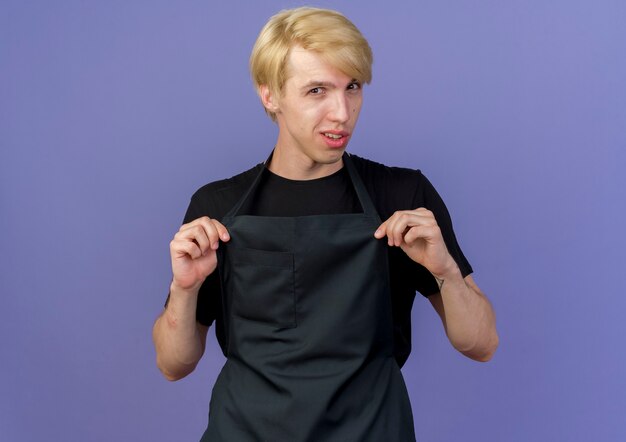 Professional barber man in apron smiling confident 