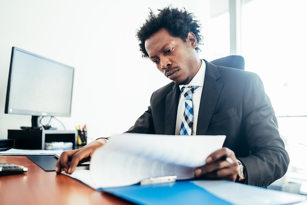 Free photo professional businessman working with some files and documents at his modern office. business concept.